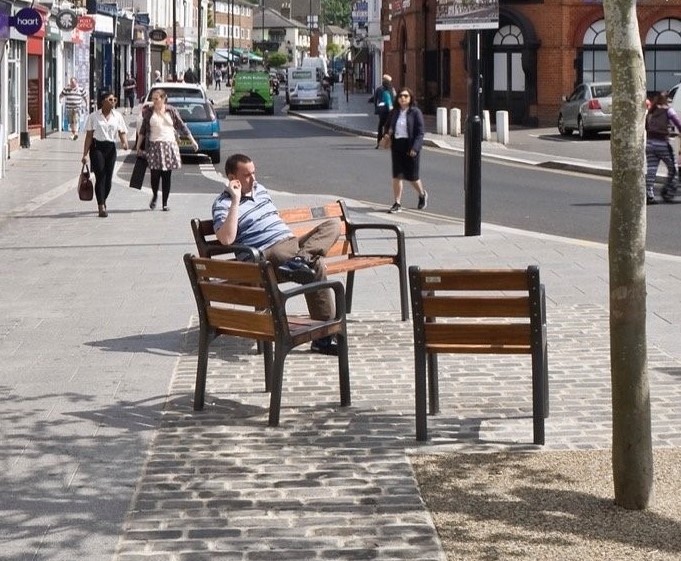 Image of bench style street furniture arrangement with integrated street tree planting.